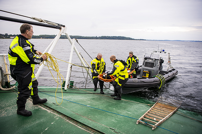 Den bjærgede passager bæres ombord på færgen. Foto: Kenneth Jensen.